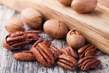 bigstock Pecan nuts on a wooden table 121630403