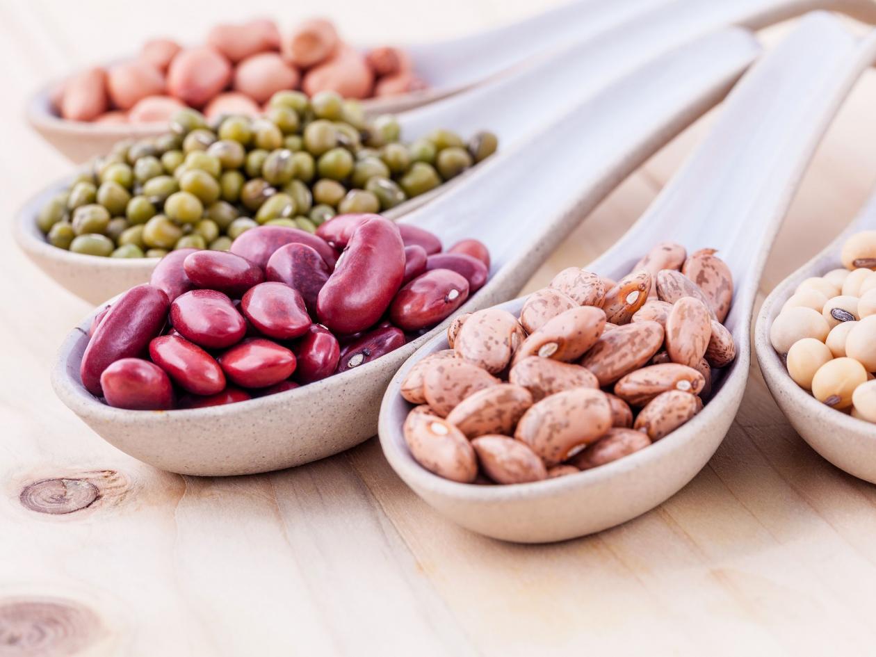 Assortment Of Beans And Lentils In Wooden Spoon On Wooden Background. Mung Bean, Groundnut, Soybean,