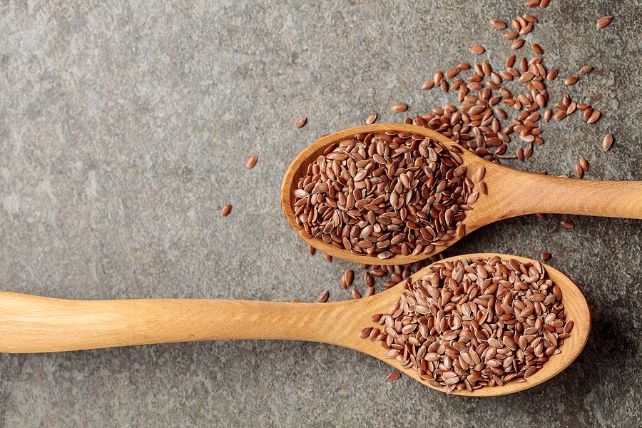 Wooden Spoons With Flaxseed On A Stone Background. Top View.