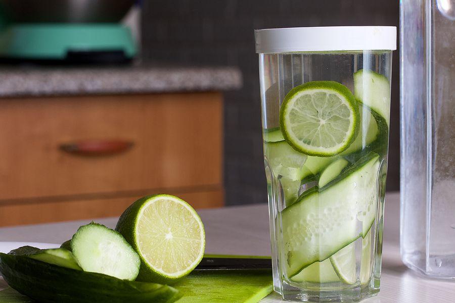 Cucumber And Lime Slices Are Filled With Water In A Glass. Cooking Water Infused With Lime And Cucum