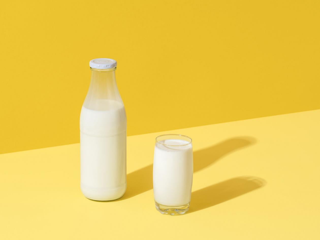 Glass And Bottle With Fresh Milk In Bright Light On A Yellow Table. Milk In Glass Bottle Minimalist