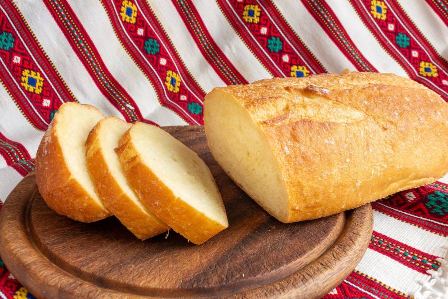 Fresh White Bread On Brown Wood Cutting Board With Sliced Pieces Of Bread