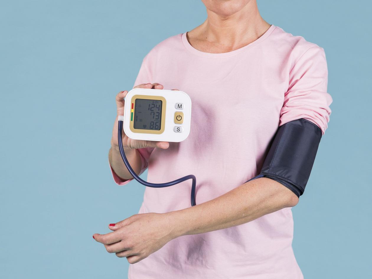 A Person Holding A Sign. Woman Showing Results Blood Pressure Electric Tonometer Screen